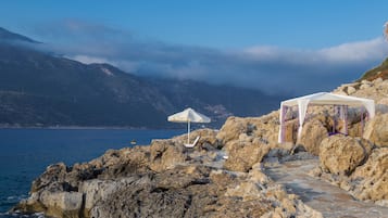 Relax in a tranquil setting with a clear view of the sea and surrounding mountains.