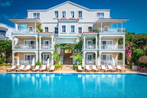 A large hotel with a swimming pool, multiple balconies, and lounge chairs. - Lukka Exclusive Hotel - Adult Only +12 (Kas)