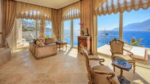 A luxurious room with a sofa, armchairs, and a table, large windows with curtains, and a view of the sea. - Lukka Exclusive Hotel - Adult Only +12 (Kas)