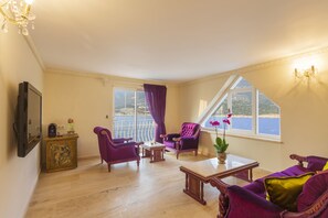 Suite – deluxe, sjøutsikt | Oppholdsområde | En 82-centimeters TV med Parabol-TV
