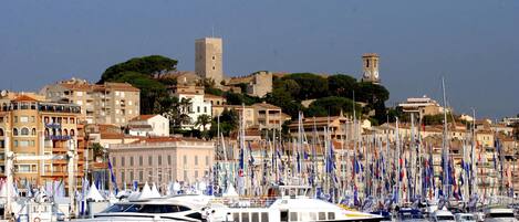 Un puerto deportivo con varios yates amarrados, una torre histórica y edificios con balcones.