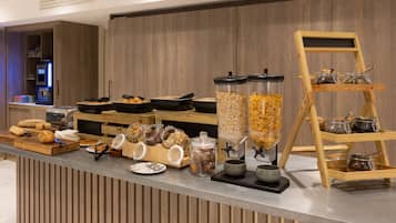 A buffet setup with various food items and containers.