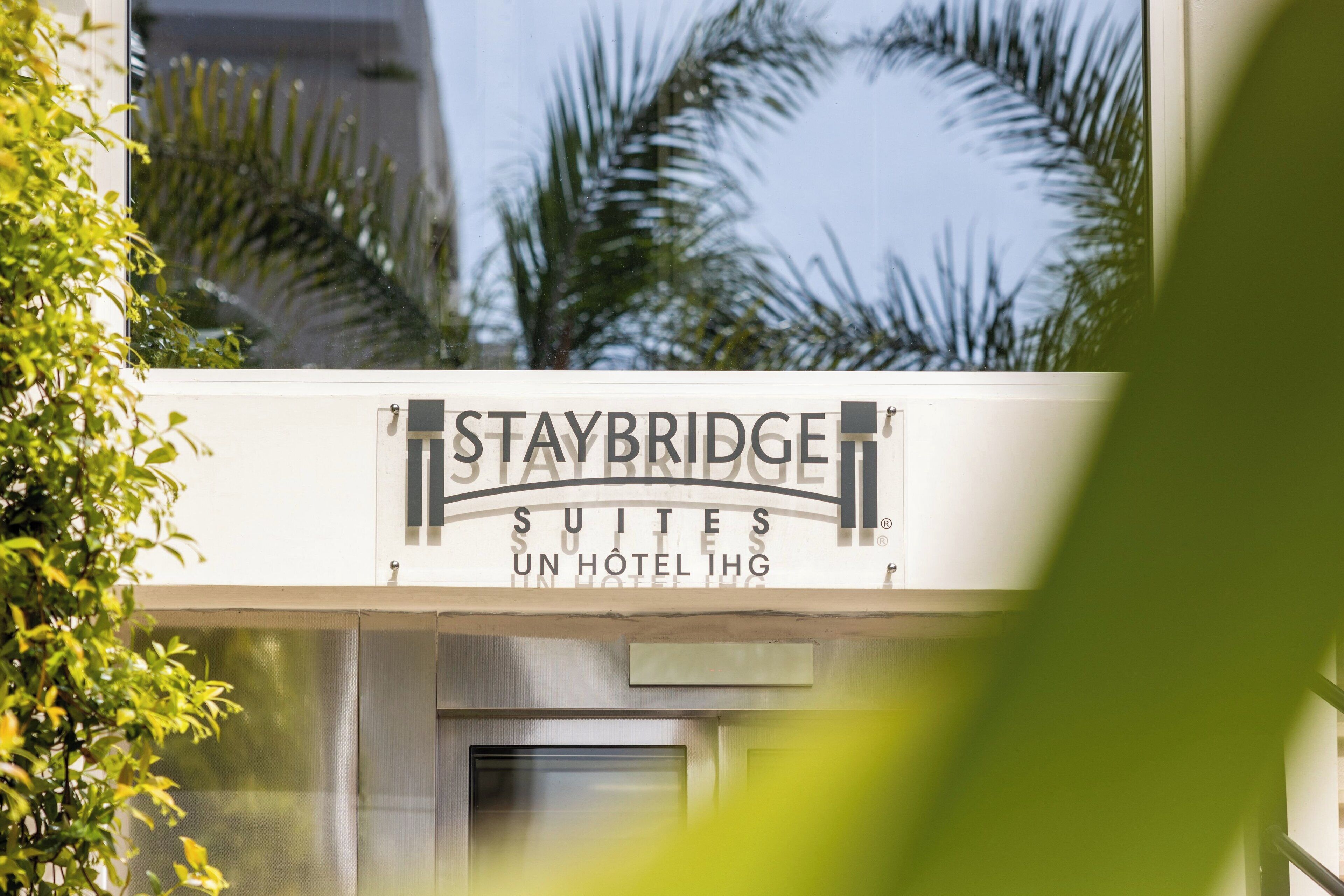 Staybridge Suites sign with palm trees in the background.