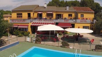 En gul byggnad med en swimmingpool, som är skyltad som restaurang, bar och hotell.