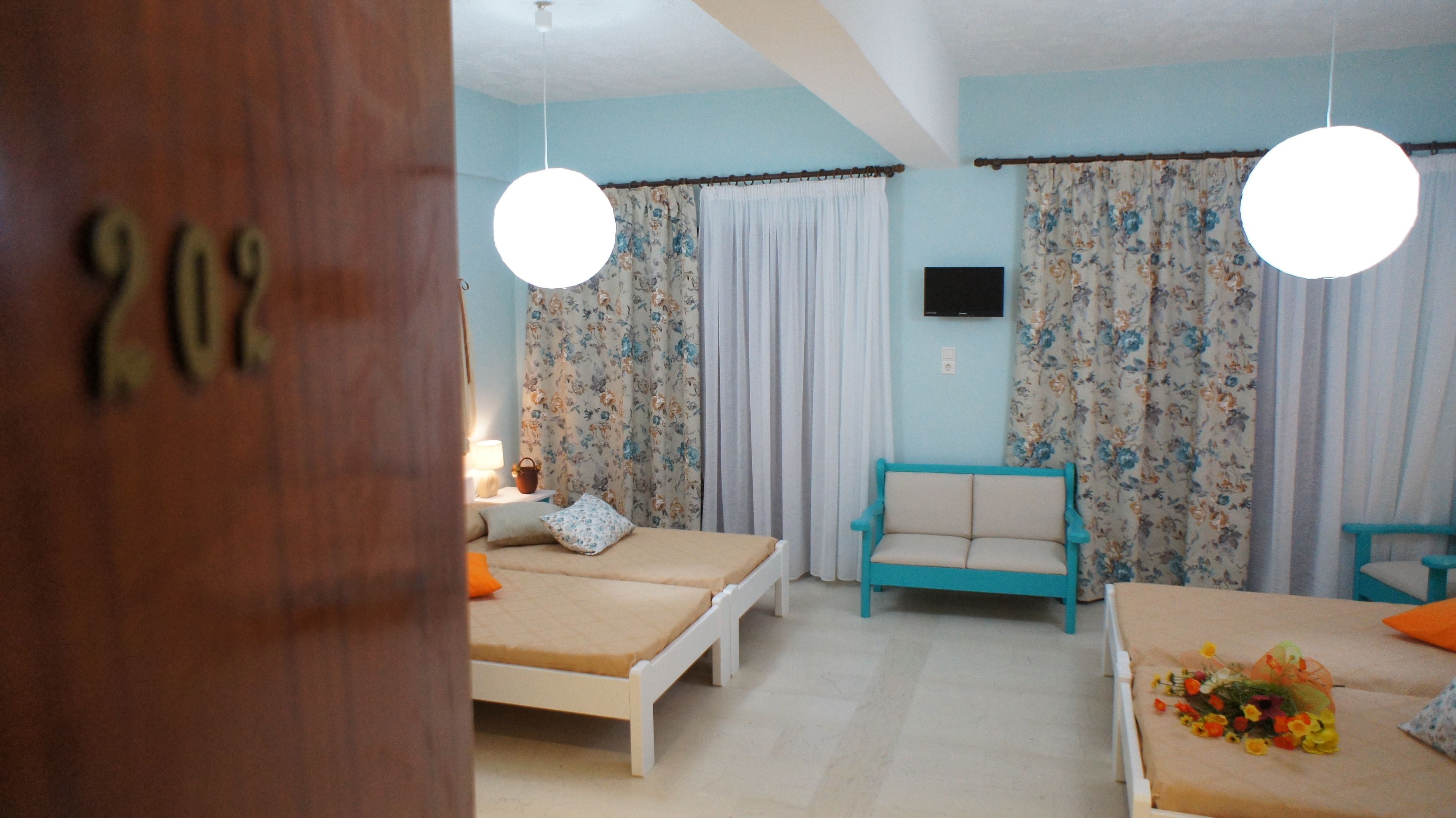 Una camera da letto con due letti, un divano e una televisione.