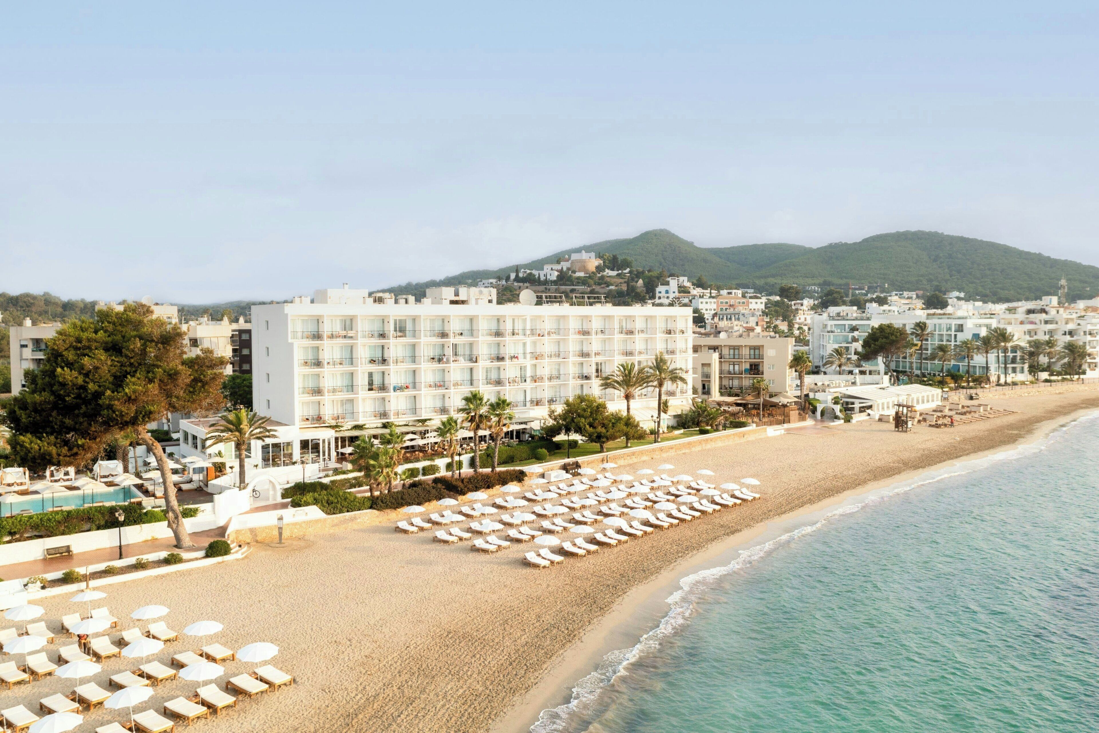 En la playa, playa de arena blanca, camastros y sombrillas 