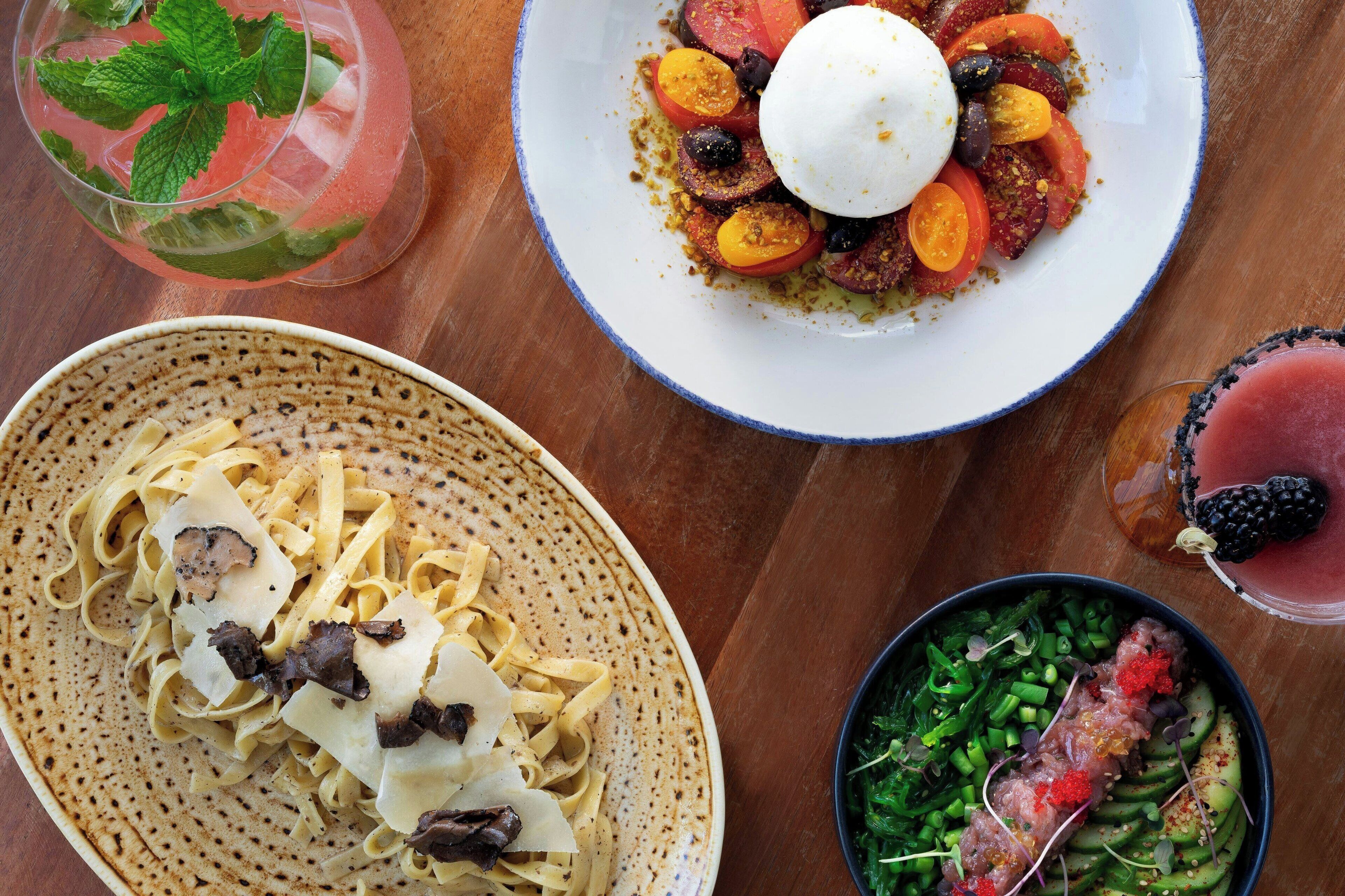 A table with various dishes including pasta, a salad, and a dessert.