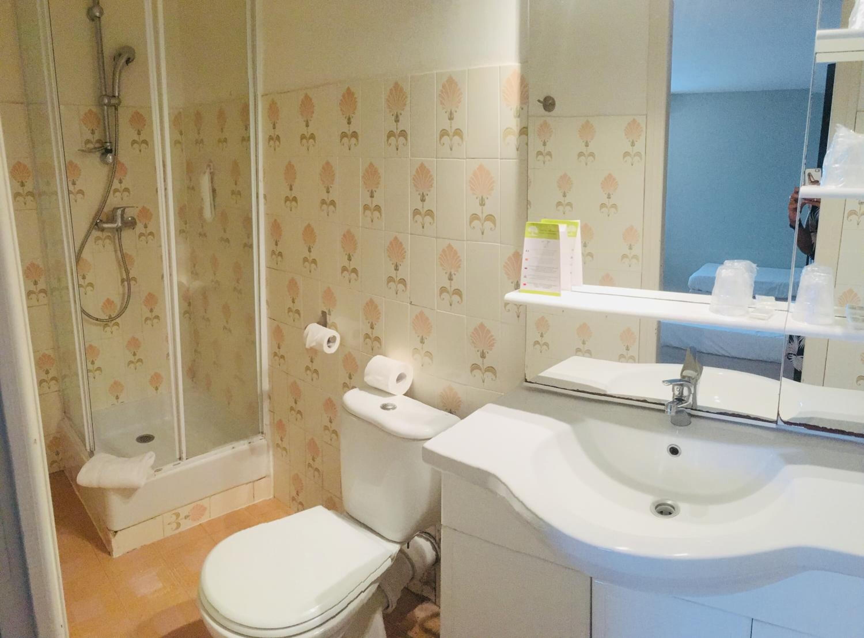 Un baño con ducha de vidrio, inodoro y lavamanos.