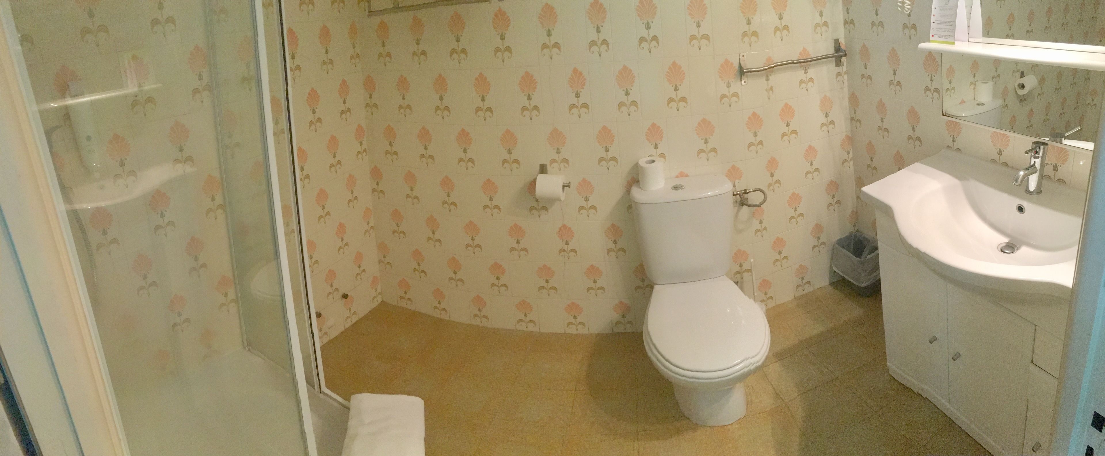 Un baño con inodoro, lavabo y ducha.
