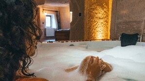Una persona en un jacuzzi con pétalos de rosa.