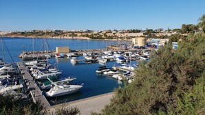 Una marina con barche ormeggiate, un molo e edifici sullo sfondo.