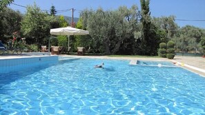 Una piscina al aire libre, sombrillas