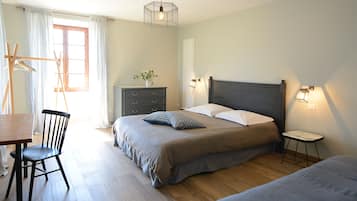 Quarto com cama, mesa de cabeceira, luminária, cadeira, cômoda e janela com cortinas.