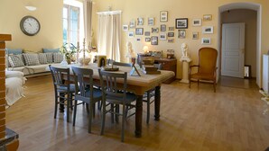 Et spiseområde med et træbord og stole, en sofa og en lysekrone.