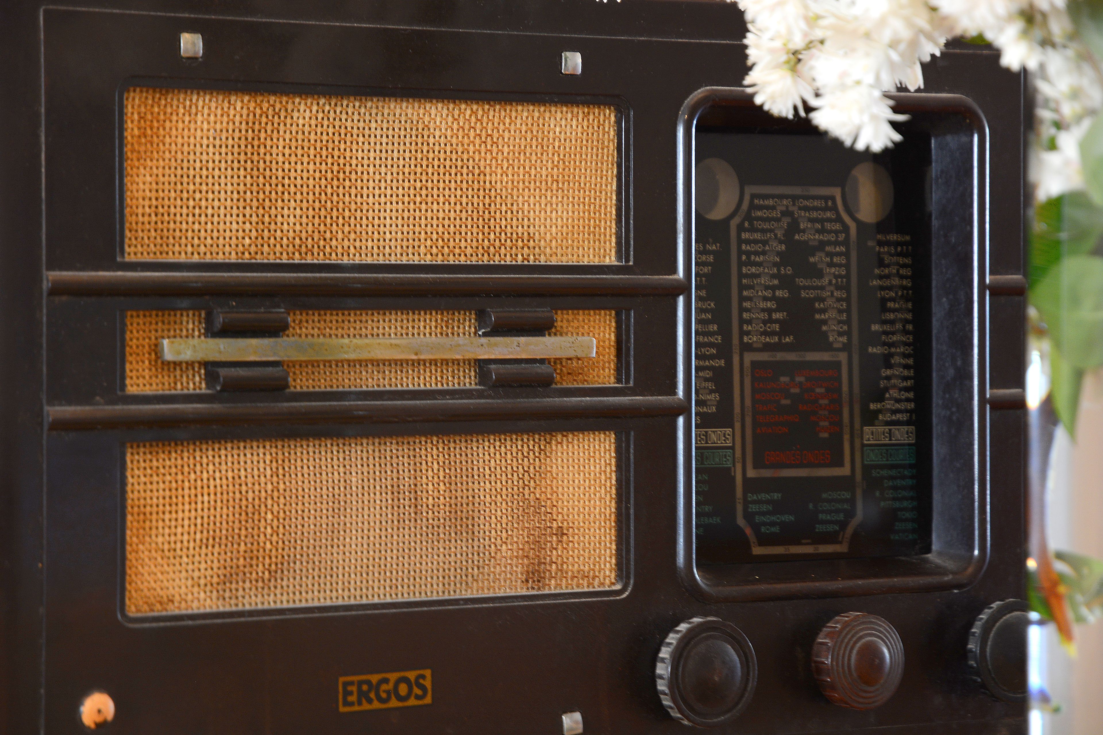 Una radio antigua con rejilla de altavoz de malla, diales de sintonización y el nombre de la marca 