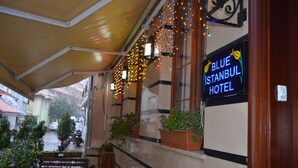 A hotel exterior with a covered walkway, potted plants, and a neon sign for the Blue Istanbul Hotel. - Hotel Blue Istanbul - Special class (Istanbul)