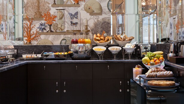 Un bufé con diversos alimentos y elementos decorativos en la pared.