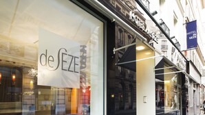 Un hotel con un gran frente de vidrio que muestra el nombre "de Seze".