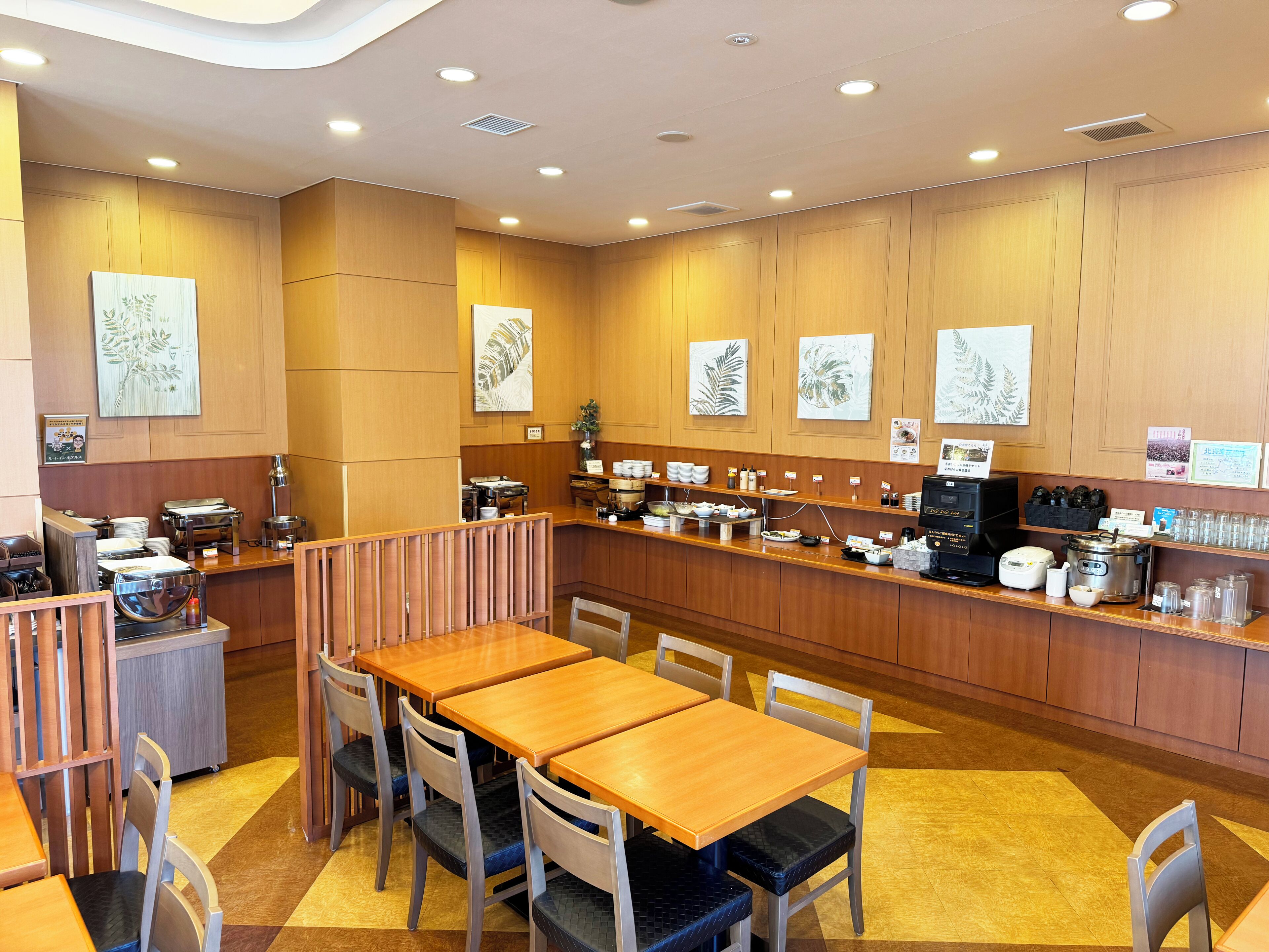 Un restaurant avec des murs lambrissés, un comptoir où sont exposés divers plats, ainsi que plusieurs tables et chaises.
