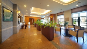 A spacious lobby with a reception desk, seating area, and large windows. - Route-Inn Grantia Shiretoko Shariekimae (Shari)
