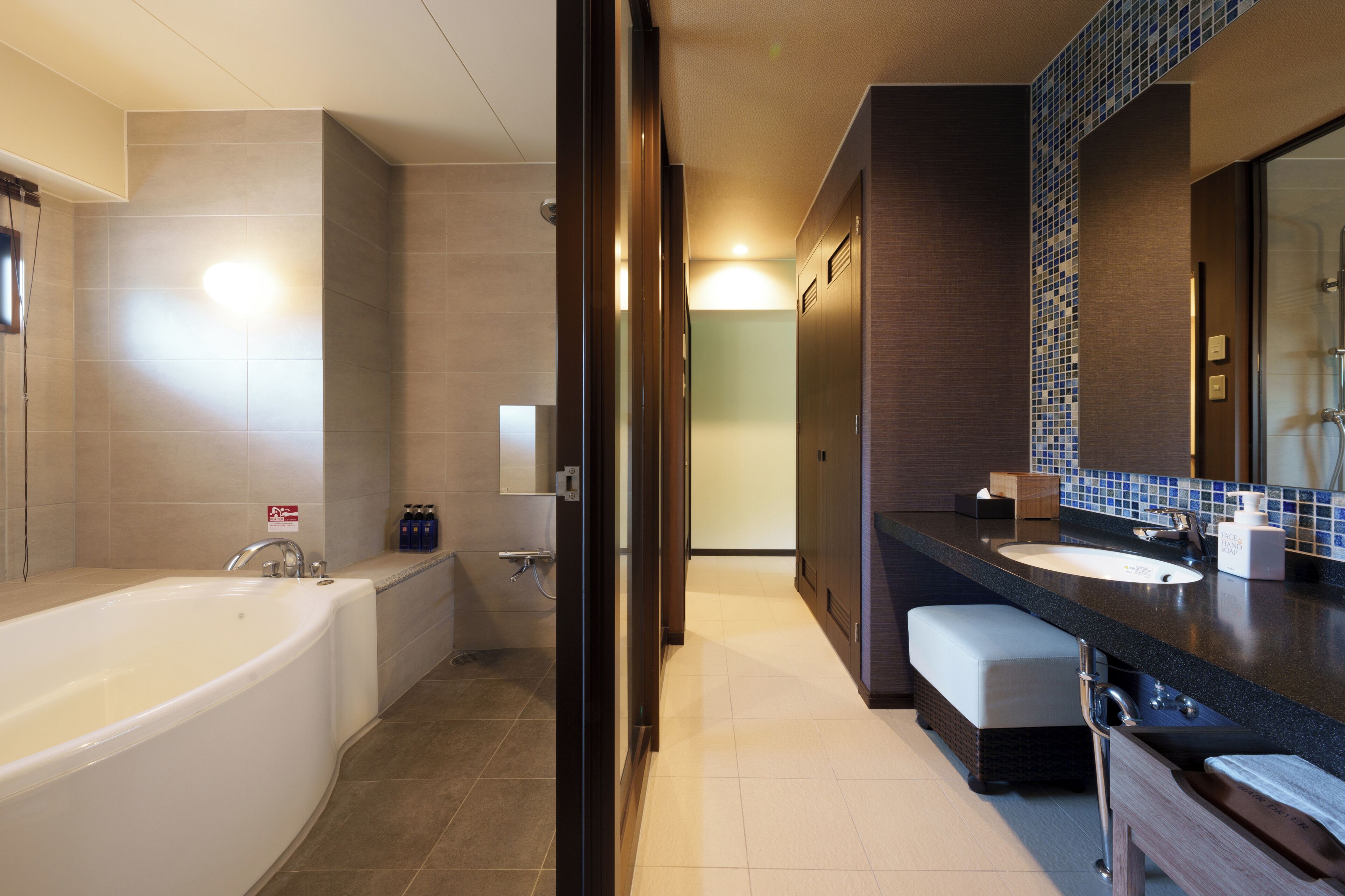 Une salle de bain moderne avec une baignoire, un lavabo et un miroir.