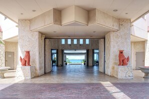 Un vestíbulo espacioso con vista al mar, columnas de piedra y dos estatuas de leones.