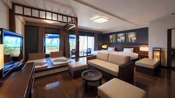 A hotel room with a balcony, a sofa, a bed, a TV, and a wall with palm tree artwork.