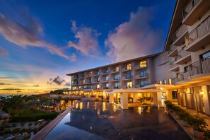 Hotel features a multi-story design with balconies and a well-maintained outdoor pool area.