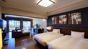 A hotel room with two beds, a desk, a TV, and a view of palm trees. - Grandvrio Resort Ishigakijima (Ishigaki)