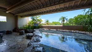 A stone pool with a clear water surface, surrounded by rocks and a wooden pergola. - Grandvrio Resort Ishigakijima (Ishigaki)