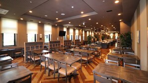 A spacious restaurant with multiple tables and chairs, a wooden floor, and a modern ceiling design. - Hotel Route - Inn Chitose Ekimae (Chitose)