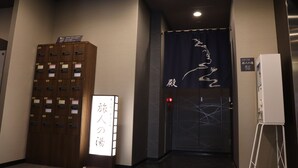 A hotel lobby with a wooden locker area, a sign with Japanese characters, and a door with a curtain. - Hotel Route - Inn Chitose Ekimae (Chitose)