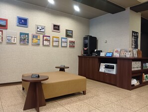 A room with a bed, a small table, a coffee machine, and a wall with framed pictures. - Hotel Route Inn Abashiri Ekimae (Abashiri)