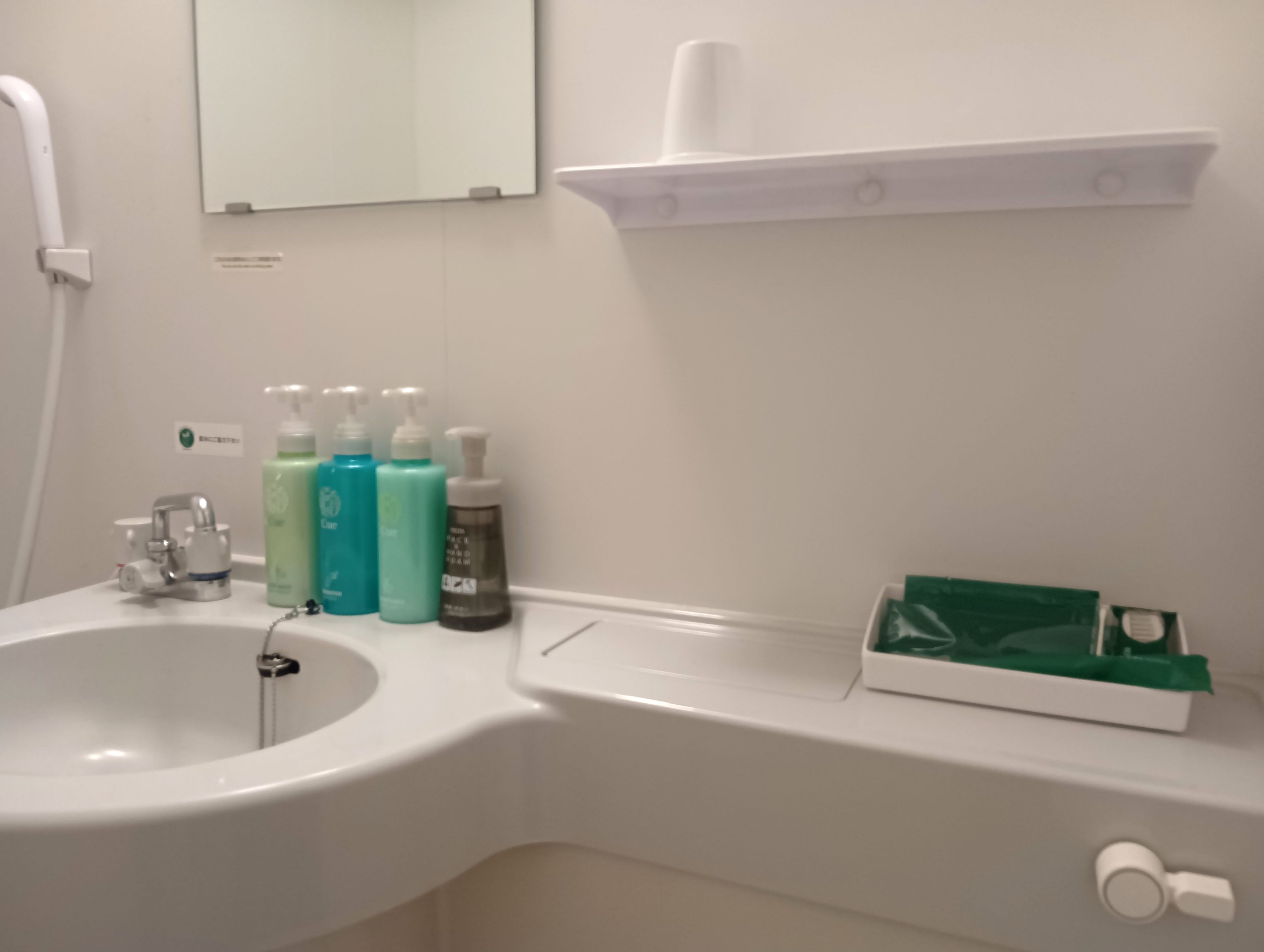 A bathroom with a sink, mirror, and toiletries.
