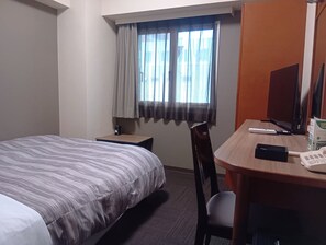 A hotel room with a bed, a desk, a chair, a television, and a window with curtains. - Hotel Route Inn Abashiri Ekimae (Abashiri)