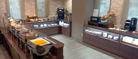 A buffet setup with various food items and a coffee station.