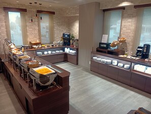 A buffet setup with various food items and a coffee station.