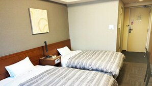 A hotel room with two beds, a nightstand with a lamp, a wall clock, and a door with a sign. - Hotel Route Inn Abashiri Ekimae (Abashiri)