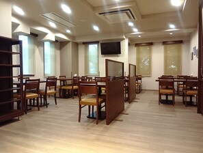 A conference room with multiple tables and chairs, recessed ceiling lights, and large windows with blinds. - Hotel Route Inn Abashiri Ekimae (Abashiri)