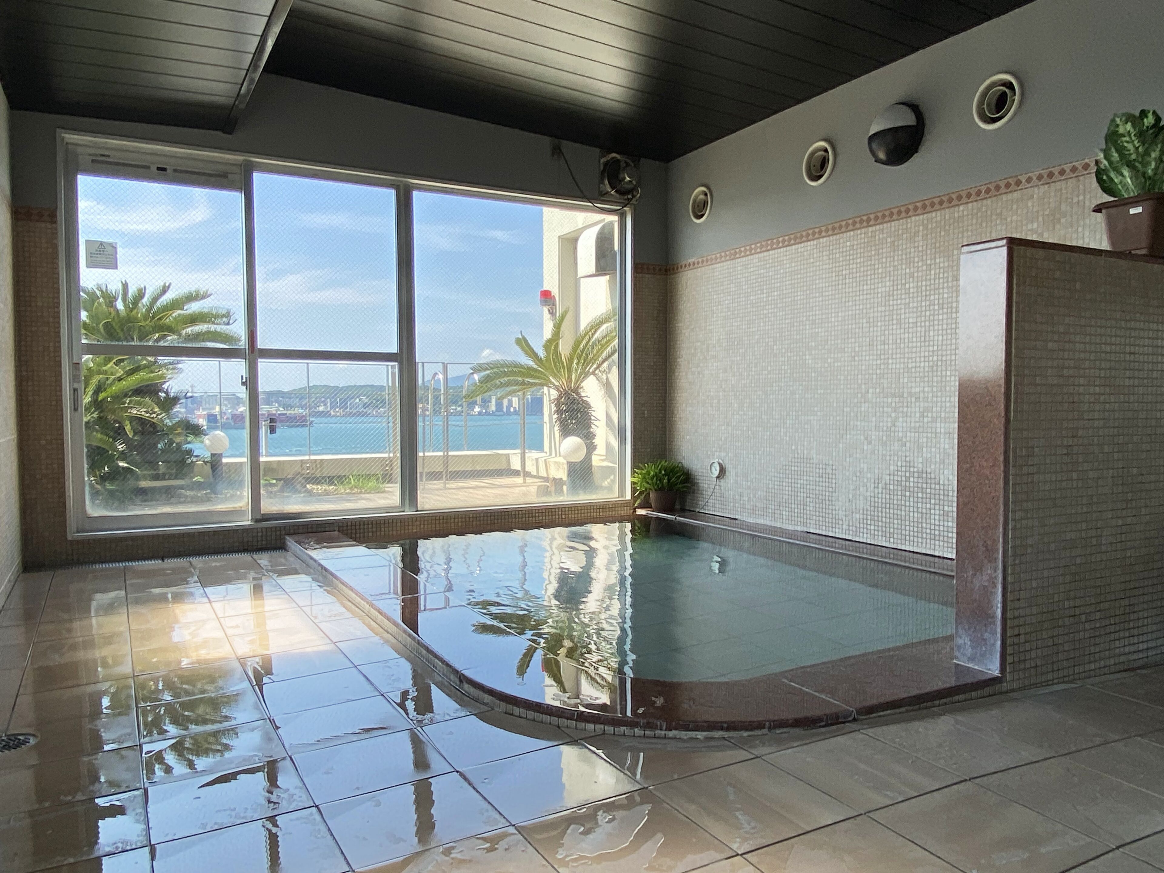 An indoor swimming pool with clear views of the sea through large windows.