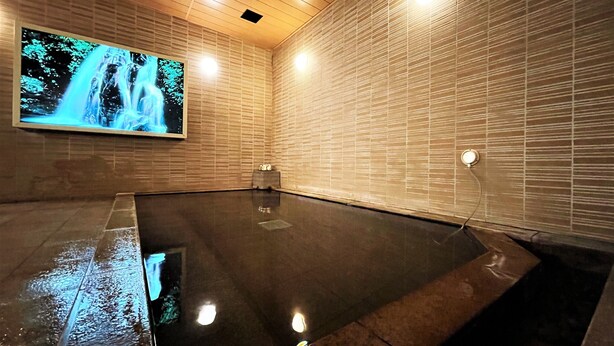 A modern indoor swimming pool with a wooden ceiling and tiled walls. - Hotel Route Inn Hakata Ekimae (Fukuoka)