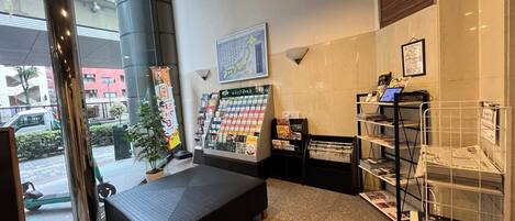 A reception area with a seating area, a display of magazines, and a map on the wall.
