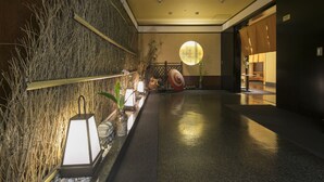 A hallway with a bamboo wall, a lantern, and a round window. - Ark Hotel Okayama (Okayama)