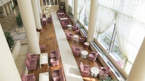 A spacious lobby with a central white carpet, rows of pink armchairs, and large windows with sheer curtains. - Ark Hotel Okayama (Okayama)