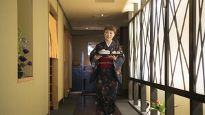 A corridor with a wooden floor, a decorative wall on the left, and a metal railing on the right. - Ark Hotel Okayama (Okayama)