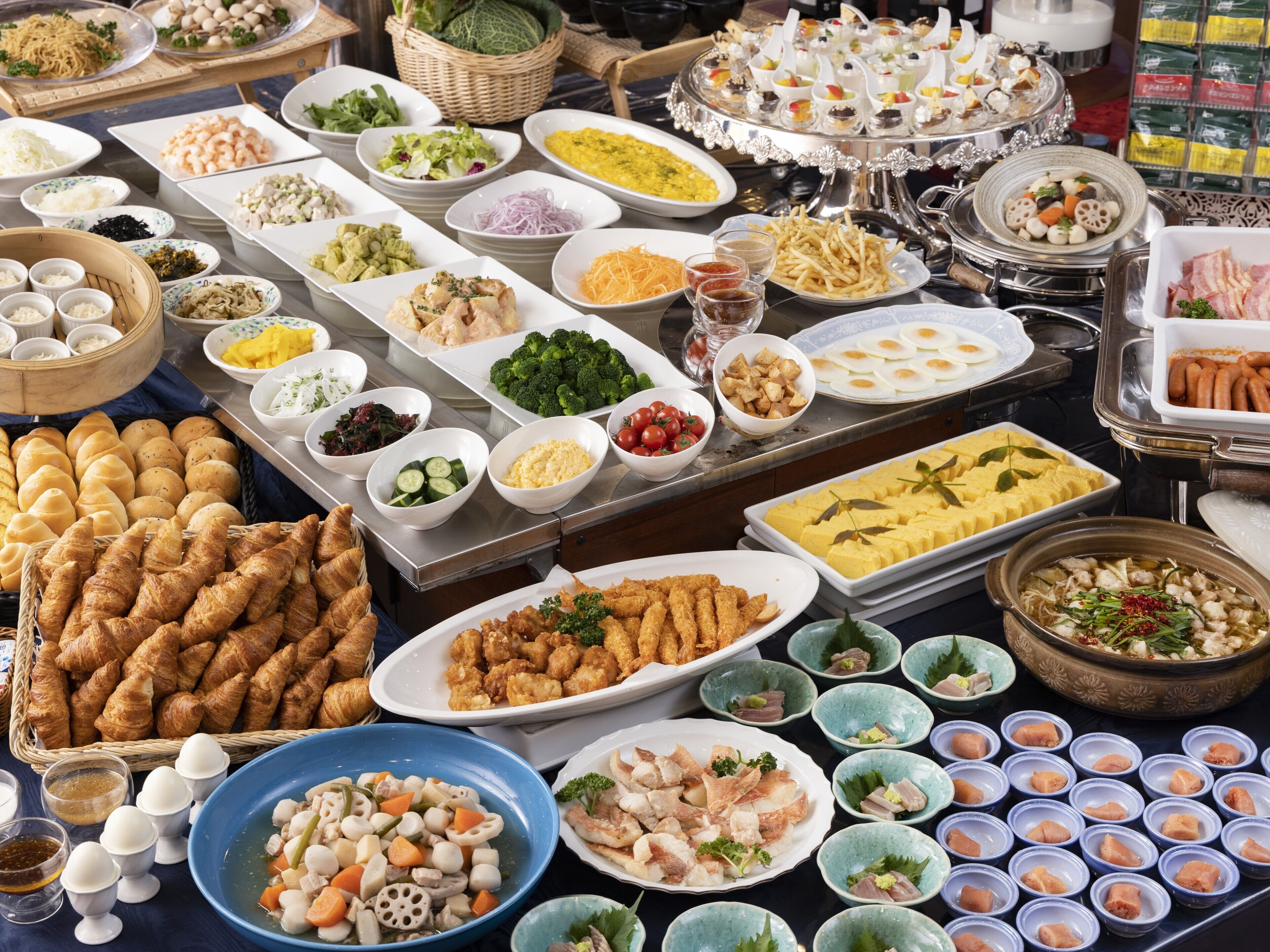 A buffet with various dishes including seafood, vegetables, and bread.
