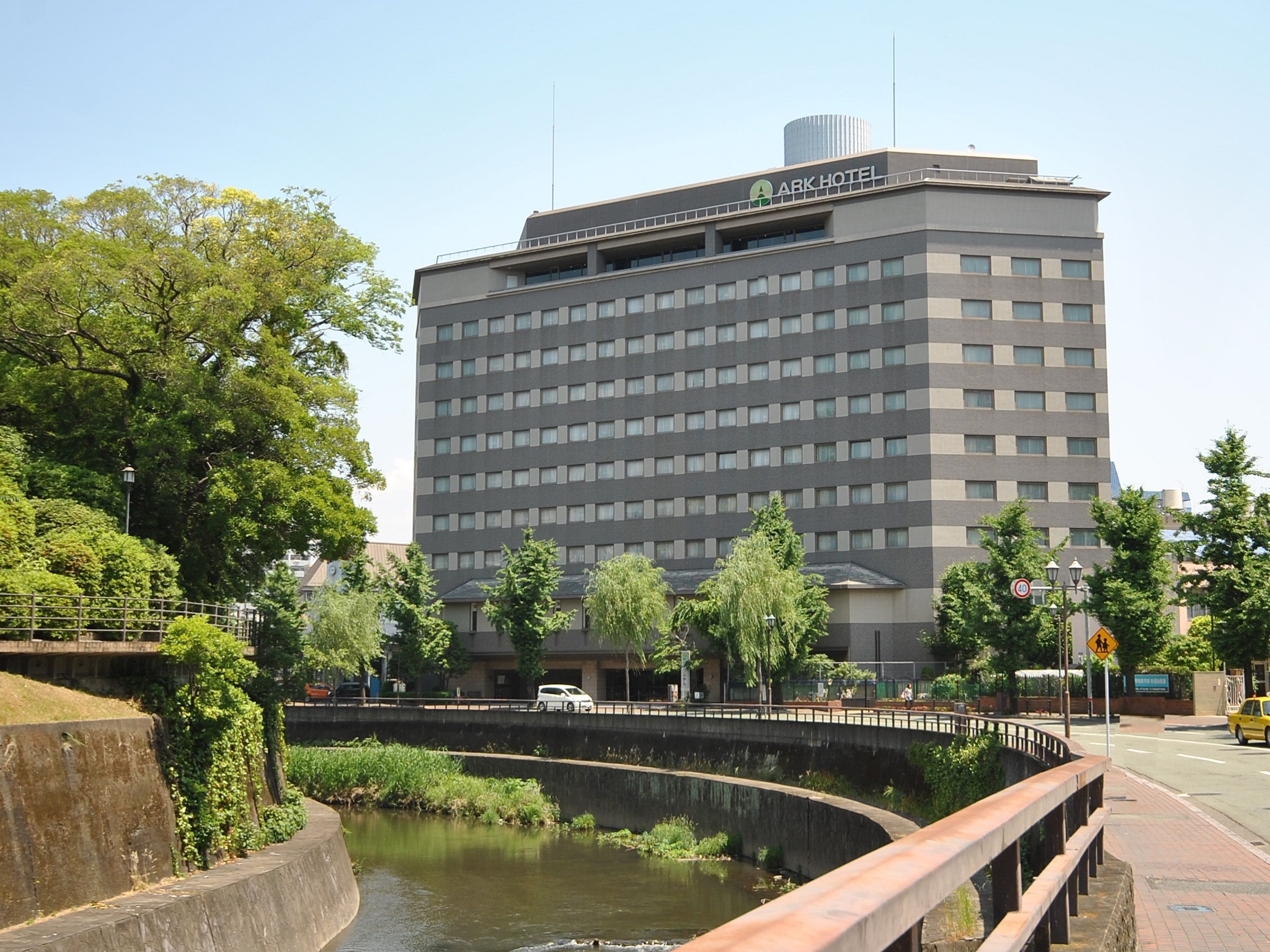 A multi-story hotel with a flat roof and a sign reading "ARK HOTEL" on the top.