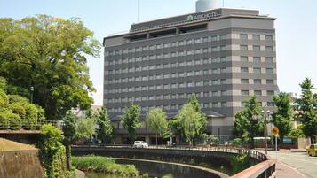 A multi-story hotel with a flat roof and a sign reading "ARK HOTEL" on the top.