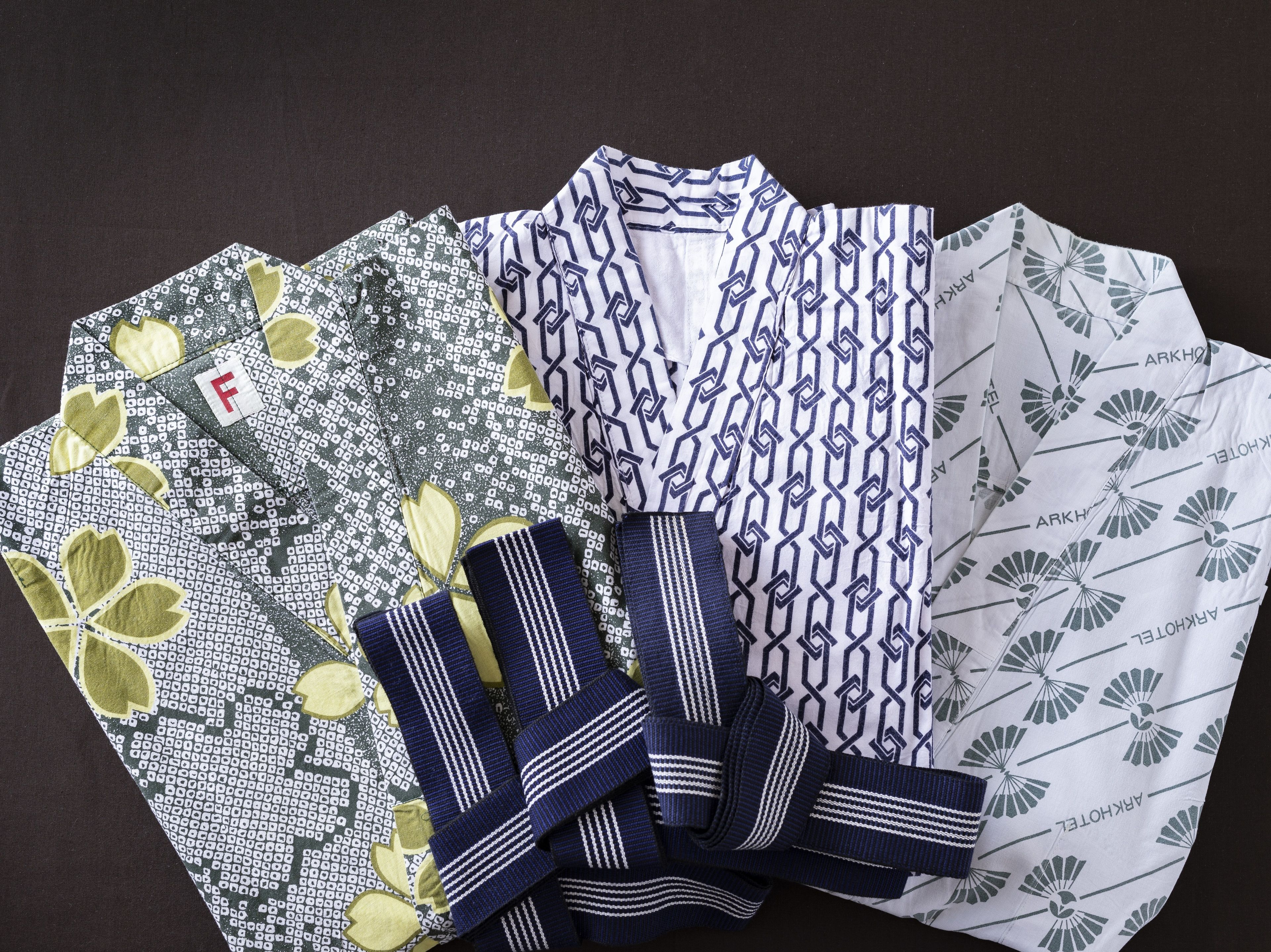 Una colección de camisas estampadas sobre una superficie oscura.