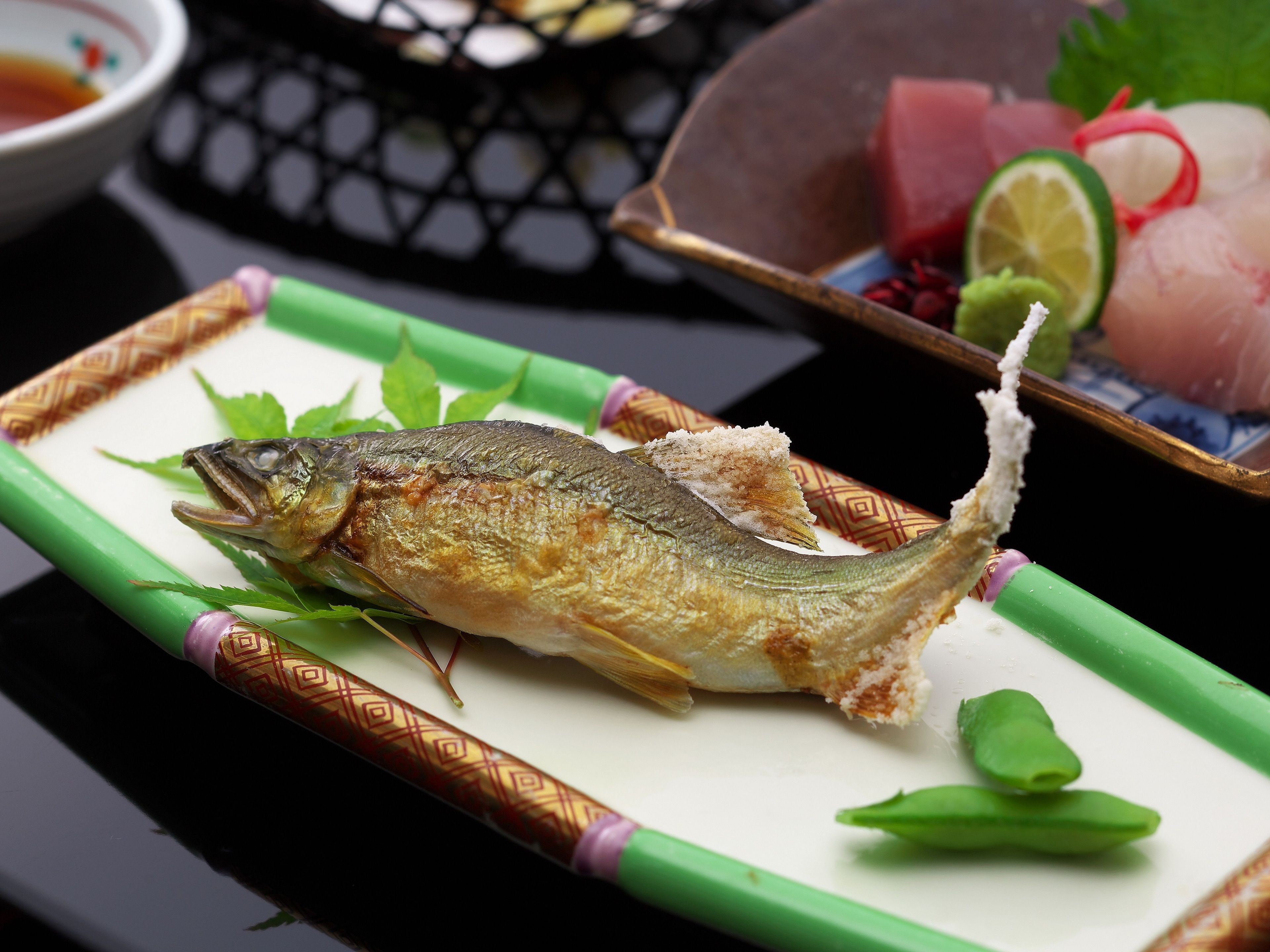 Un plato de pescado sobre un plato verde con adornos.